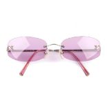 CHANEL - a pair of sunglasses. Designed as rimless pink-tinted lenses, engraved 'Chanel' and with '