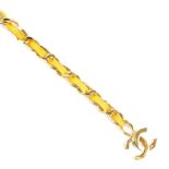 CHANEL - a chain belt. The gold-tone curb-link chain, interwoven with yellow leather, pierced CC