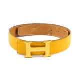HERMES - a reversible logo buckle belt. Designed with pebbled mustard yellow leather to one side and