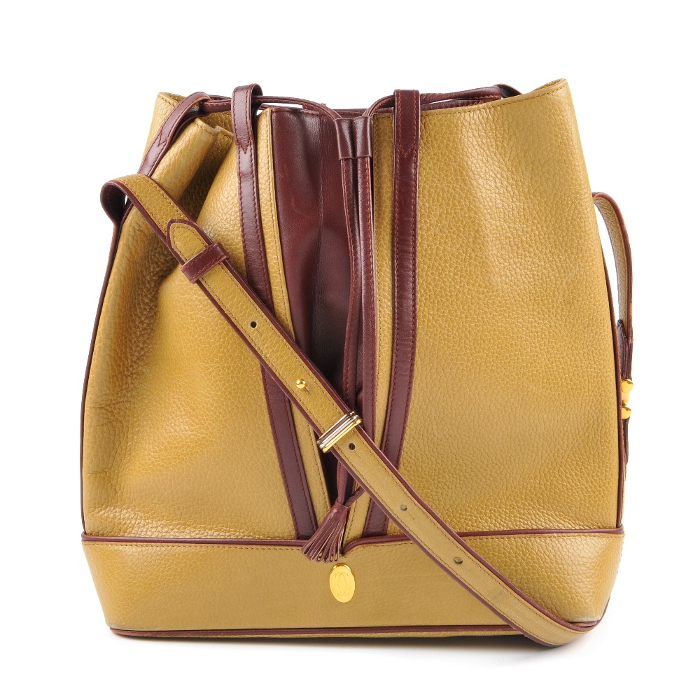 CARTIER - a two-tone bucket tote handbag. Designed with a pebbled mustard leather exterior and