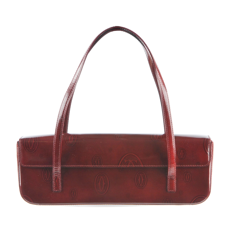 CARTIER - a Happy Birthday long baguette bag. Crafted from burgundy patent leather embossed with