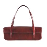 CARTIER - a Happy Birthday long baguette bag. Crafted from burgundy patent leather embossed with