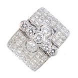 A diamond dress ring. Comprising a brilliant-cut diamond cross, with pave-set diamond sides.