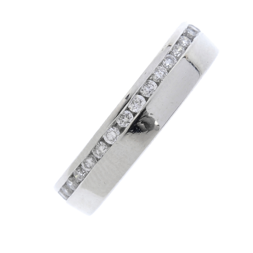 A platinum diamond full-circle eternity ring. The brilliant-cut diamond line, within an off-centre