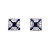 A pair of sapphire and diamond earrings. Each designed as a square-shape sapphire, within a