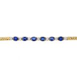 A 14ct gold sapphire and diamond bracelet. Designed as a series of oval-shape sapphires, with