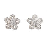 A pair of diamond floral cluster earrings. The brilliant-cut diamond cluster, within a similarly-cut