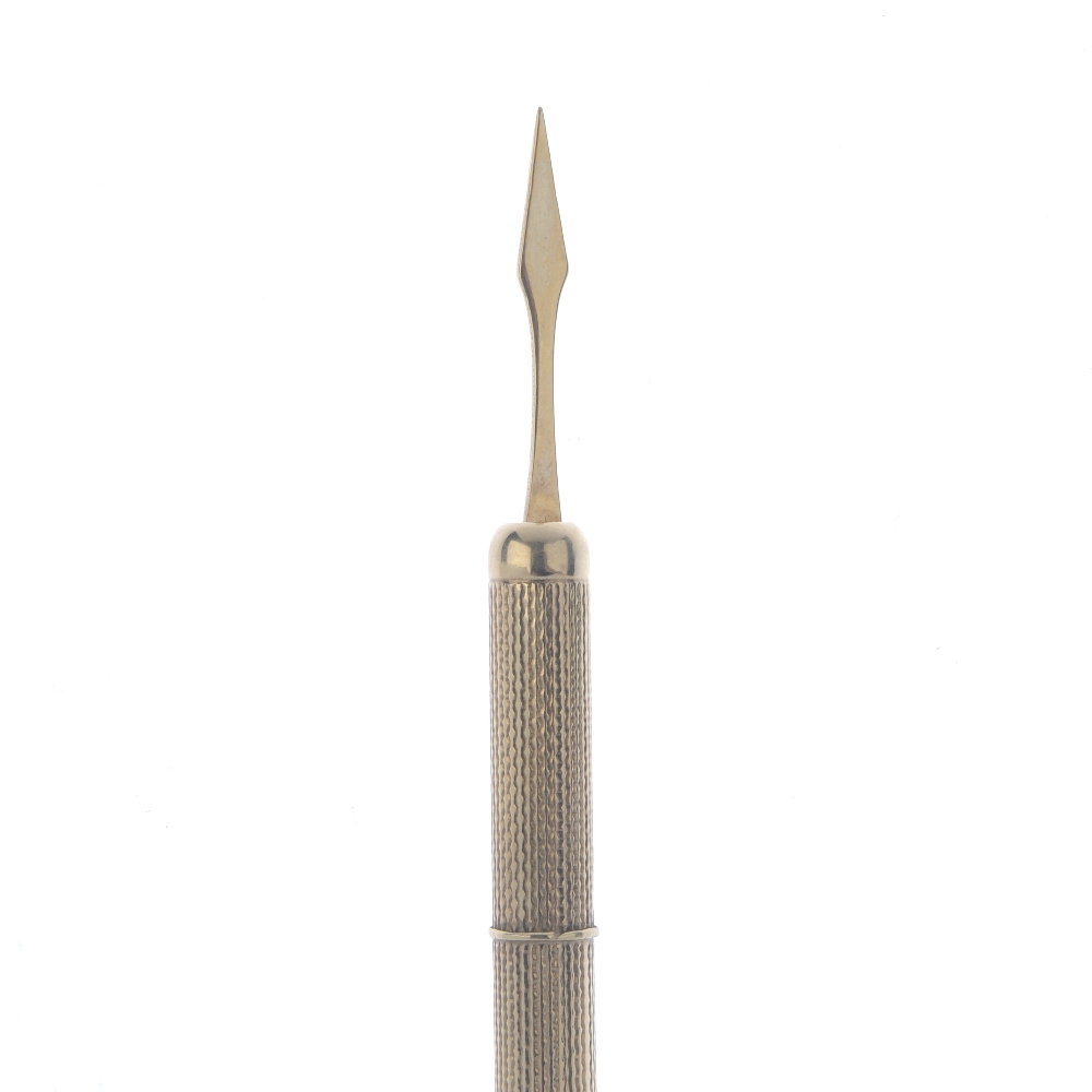 A 9ct gold retractable toothpick. With engine-turned case. Hallmarks for Birmingham, 1967. Length (