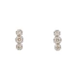 A pair of 18ct gold diamond earrings. Each designed as a slightly graduated brilliant-cut diamond