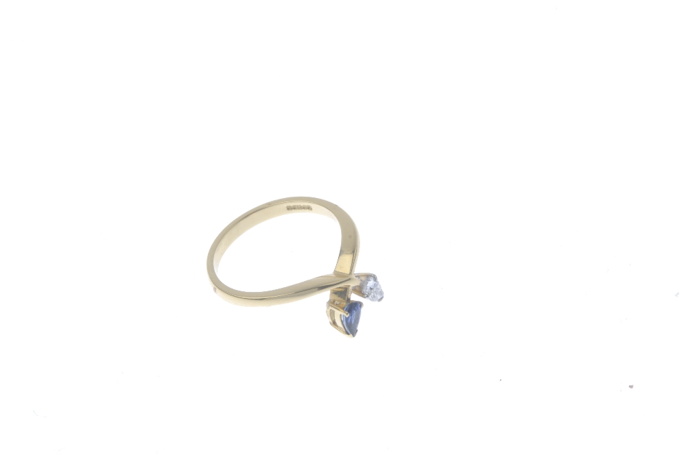 An 18ct gold diamond and sapphire dress ring. The crossover band, with pear-shape diamond and - Image 4 of 4