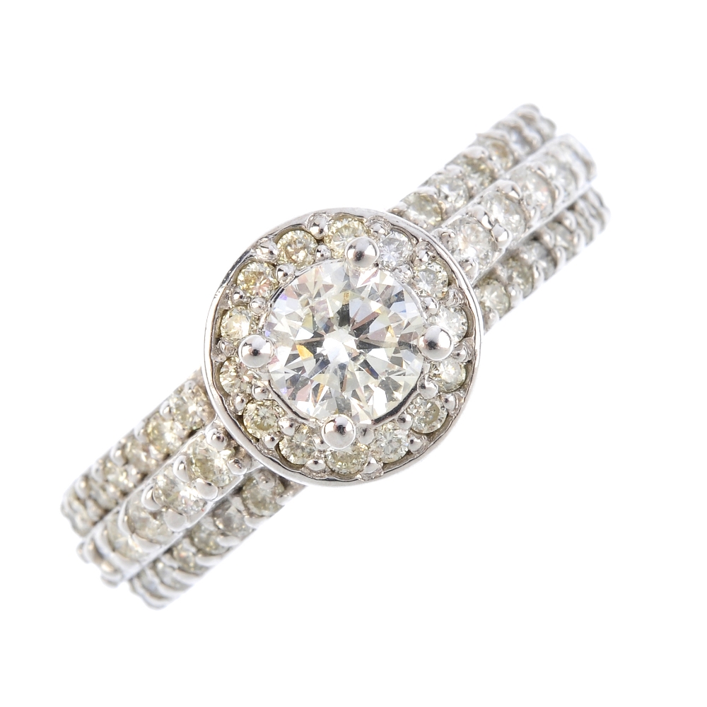 A 14ct gold diamond dress ring. The brilliant-cut diamond, with similarly-cut diamond surround and