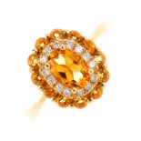 An 18ct gold citrine and diamond cluster ring. The oval-shape citrine, with brilliant-cut diamond