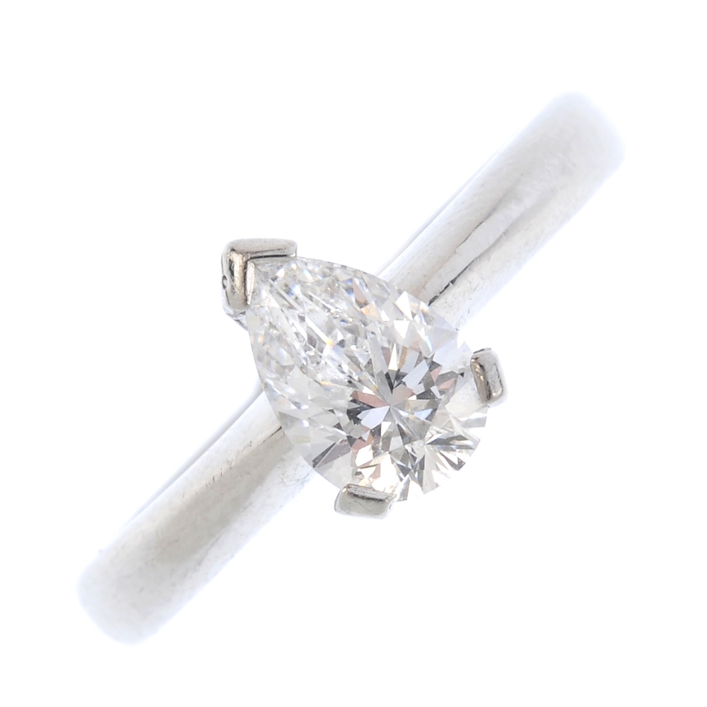 A platinum diamond single-stone ring. The pear-shape diamond, with tapered shoulders and plain band.