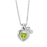 An 18ct gold peridot and diamond pendant. The heart-shape peridot within a scrolling ribbon mount.