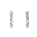 A pair of diamond earrings. Each comprising an illusion-set brilliant-cut diamond four-stone line.