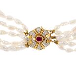 A cultured pearl bracelet. Comprising six cultured pearl strands, gathered by an oval-shape ruby and