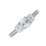 A diamond three-stone ring. The graduated oval-shape diamond line, with brilliant-cut diamond line