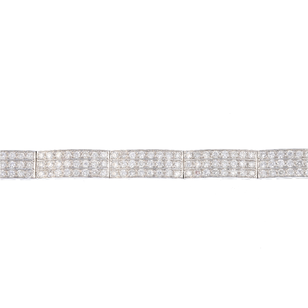 A diamond bracelet. Designed as three brilliant-cut diamond lines, with polished bar spacers and