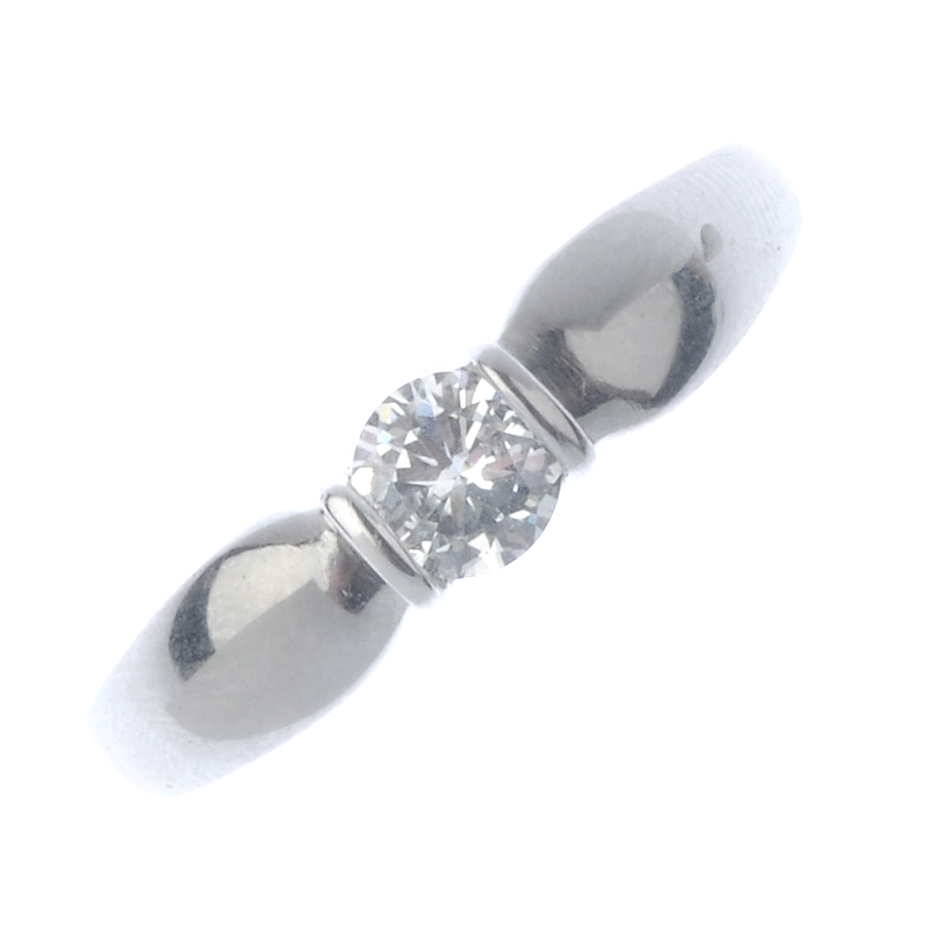 A platinum diamond single-stone ring. The brilliant-cut diamond, with tapered shoulders. Estimated