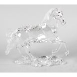 A Swarovski crystal horse figurine, modelled with one foreleg raised on an integral naturalistic