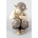 A Royal Copenhagen figure, modelled as the infant Pan playing his pipes, with marks to base, No.