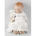 A box containing an Armand Marseille bisque headed 'Dream Baby' doll, a composition pot headed doll,