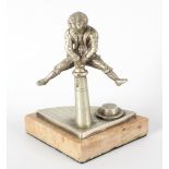 A late 19th century cast metal pocket watch stand modelled as a young boy leaping over a street
