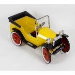 A modern pressed metal child's pedal car, the yellow painted body with tubular metal window frame