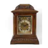 A late 19th century carved and stained walnut bracket style mantle clock, the dial marked 'W