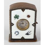 A hide cased desk clock, the enamelled face decorated with four leaf clover, lady bird, horse shoe