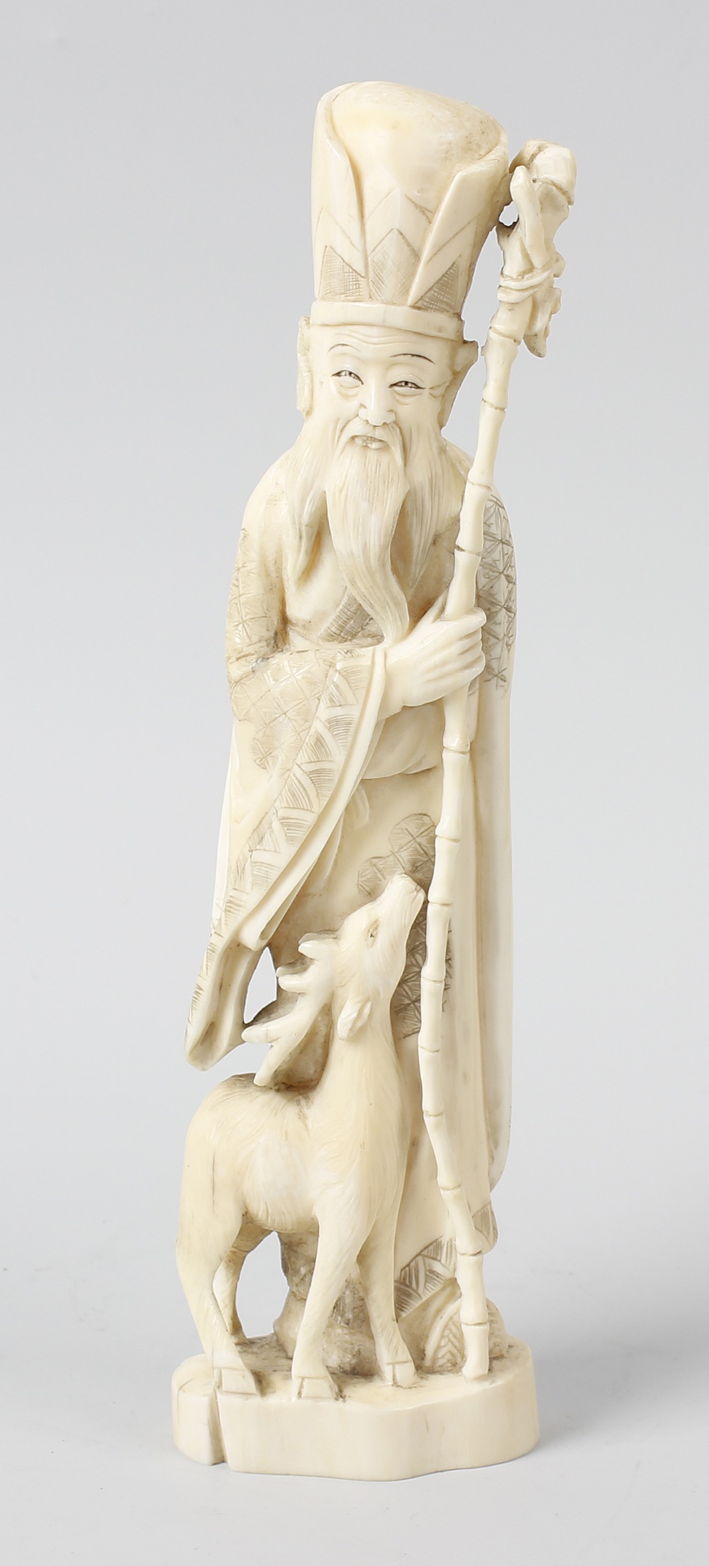 A Japanese late Meiji/Taisho period carved ivory okimono, modelled as Fukurokuju, the bearded