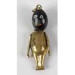 A World War I fumsup good luck charm, with gilt metal body, ebonised wooden head and painted face,