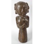 An early carved ethnographic figure modelled as a female with plaited hair and carved facial