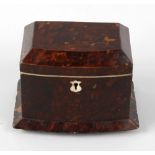 A small early 19th century tortoiseshell tea caddy. The hinged bowfront cover with canted angles,