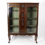 An Edwardian mahogany display cabinet or vitrine. The moulded cornice over a pair of shaped arch-