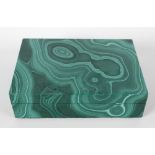 A malachite box and cover of rectangular form, the hinged opening cover lifting to reveal a black