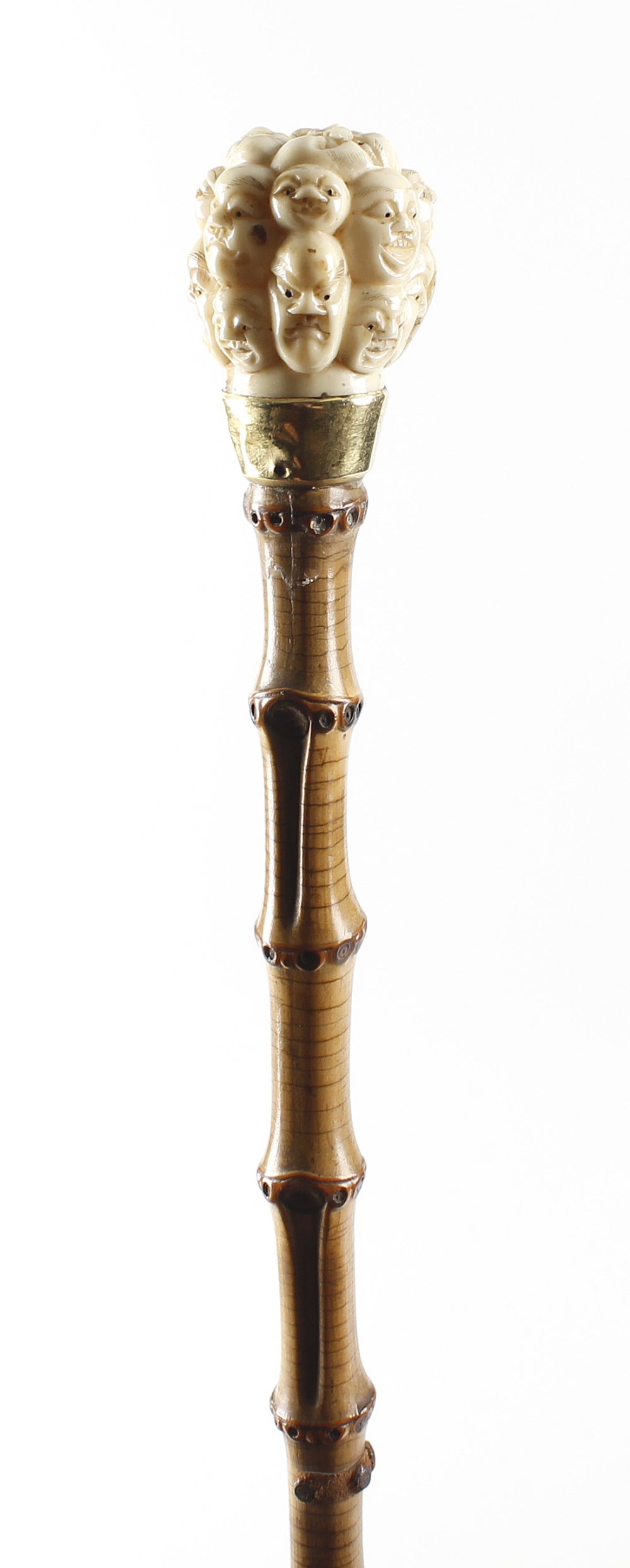 A 19th century walking cane, the carved ivory Japanese Meiji period handle formed as a group of