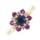 A sapphire, diamond and ruby cluster ring. The circular-shape sapphire, with single-cut diamond