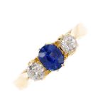 An Edwardian 18ct gold sapphire and diamond three stone ring. The oval-shape sapphire, with old-