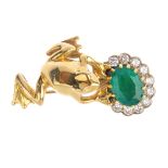 An emerald and diamond frog brooch. The frog, resting against an oval-shape emerald and brilliant-