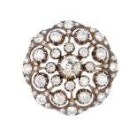 A late Victorian silver and gold diamond cluster brooch. Of openwork design, the old-cut diamond,