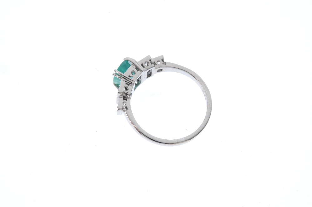 An emerald and diamond ring. The oval-shape emerald, with brilliant-cut diamond stepped sides. - Image 4 of 5