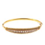 A late Victorian 15ct gold split pearl hinged bangle. The graduated split pearl line, with