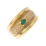 An 18ct gold emerald and diamond dress ring. The oval emerald cabochon, with pave-set diamond