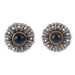 A pair of onyx and diamond ear clips. Each of bi-colour design, the circular cabochon, with rose-cut