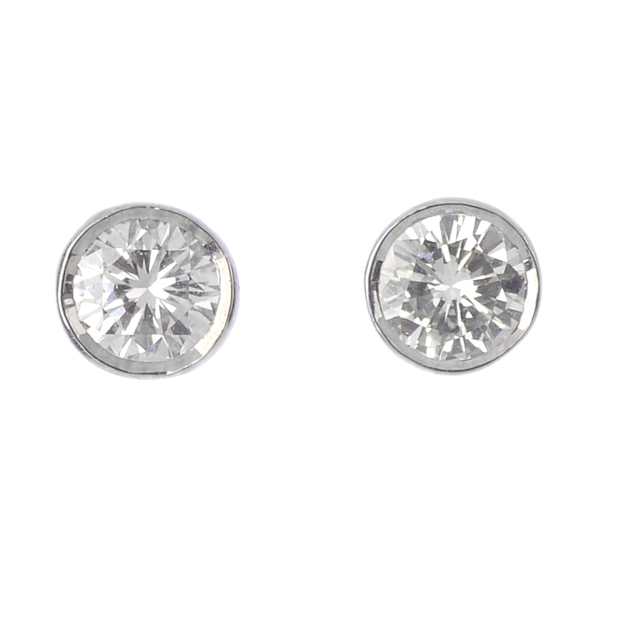 A pair of brilliant-cut diamond collet stud earrings. Estimated total diamond weight 0.75ct, H-I