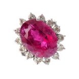 A tourmaline and diamond cluster ring. The oval-shape pink tourmaline, with a brilliant-cut