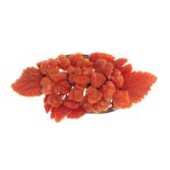 A carved coral brooch. Of oval outline set with carved coral flowers and leaves. Length 5.7cms.