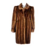 A demi-buff mink three-quarter coat. Featuring a mandarin collar, hook and eye clip fastenings,