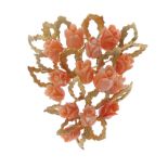 A coral brooch. Designed as openwork gold plated leaves with carved coral flower buds. Length 5.